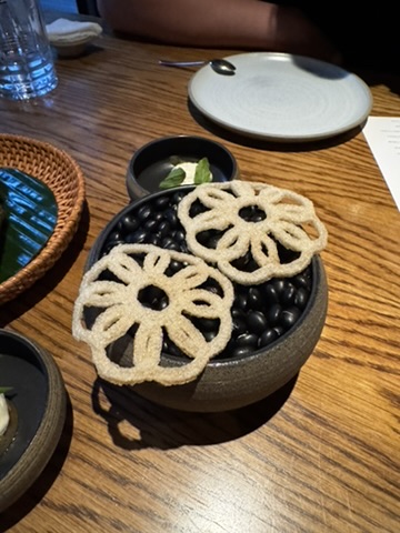 Banana kerupuk course at August Jakarta served in a small dark bowl