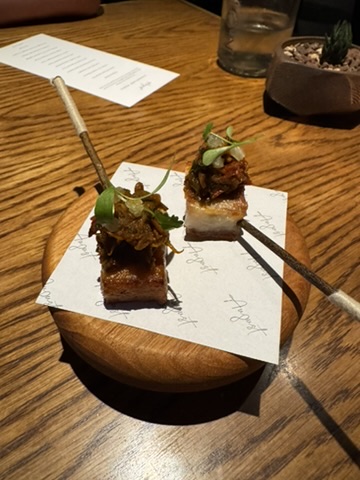 Pork belly woku bite served on crisp rice at August Jakarta