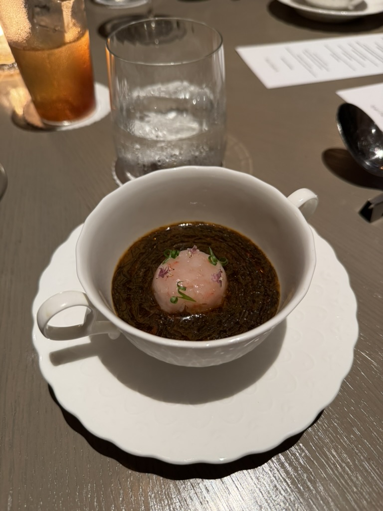 Kindling crab custard served in a white cup with amaebi and dark sauce