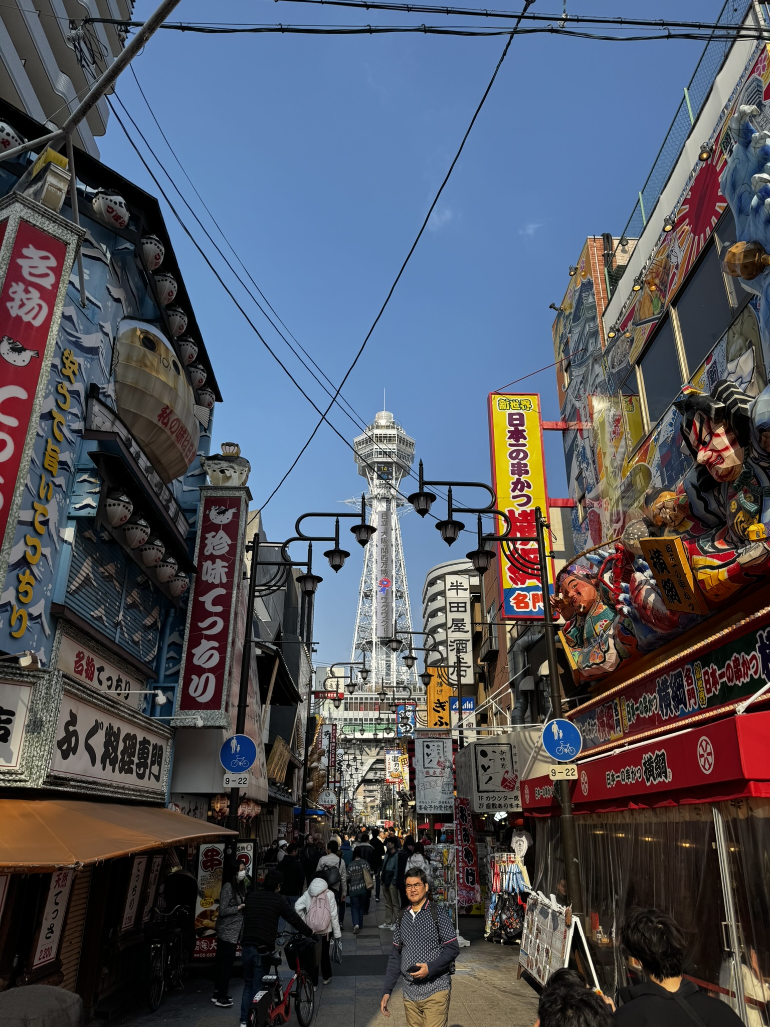 Tsutenkaku Tower seen from the busy Shinsekai street