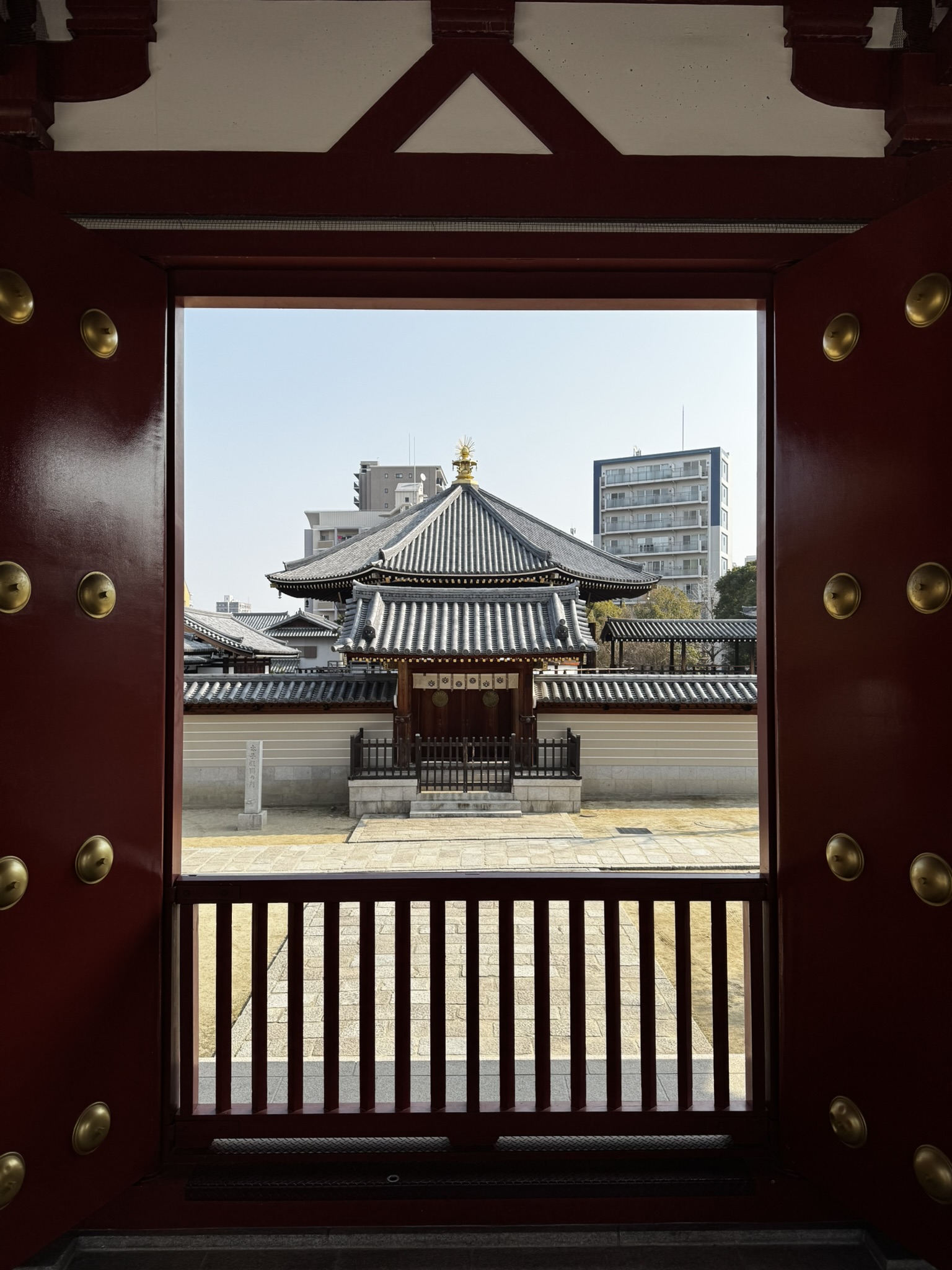 Temple building framed by a red doorway at Shitennoji