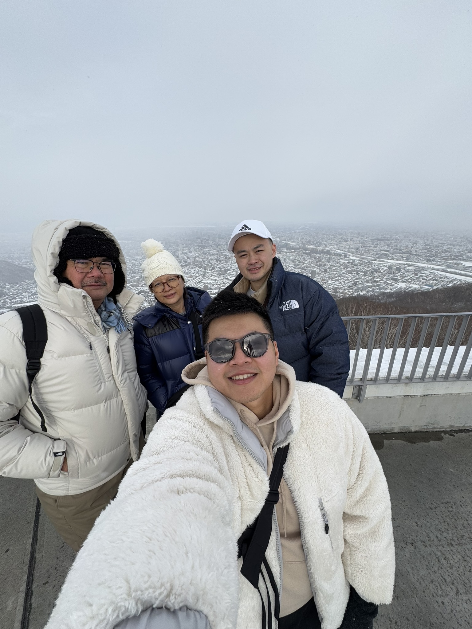 Family selfie at Mt. Moiwa summit with Sapporo view behind