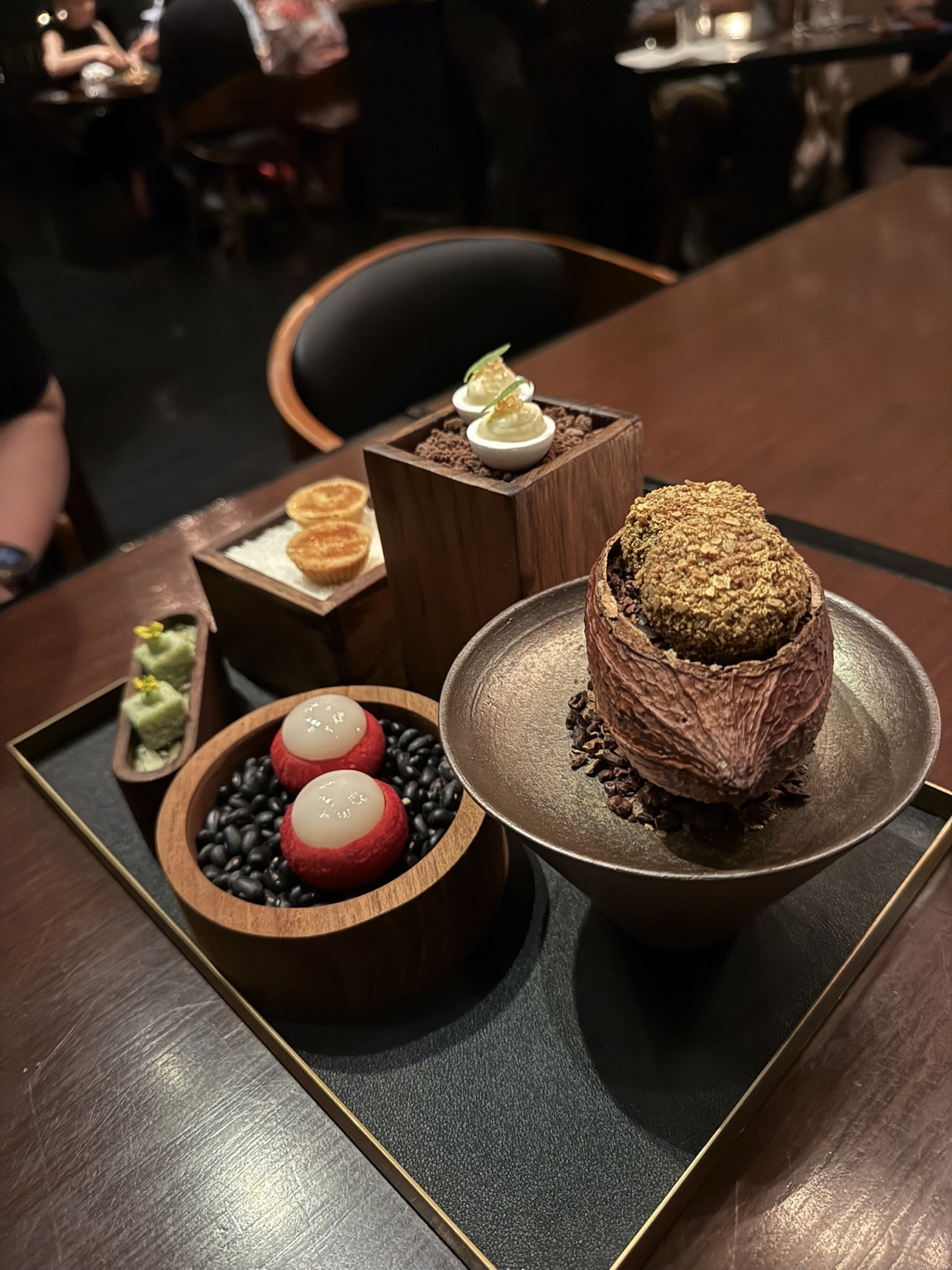 Saawaan dessert and petit fours arranged on a dark tray