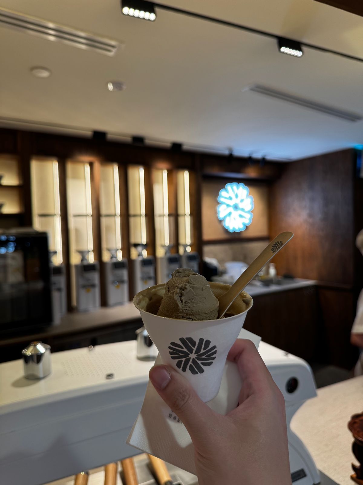 Cup of matcha gelato held up inside a dessert shop