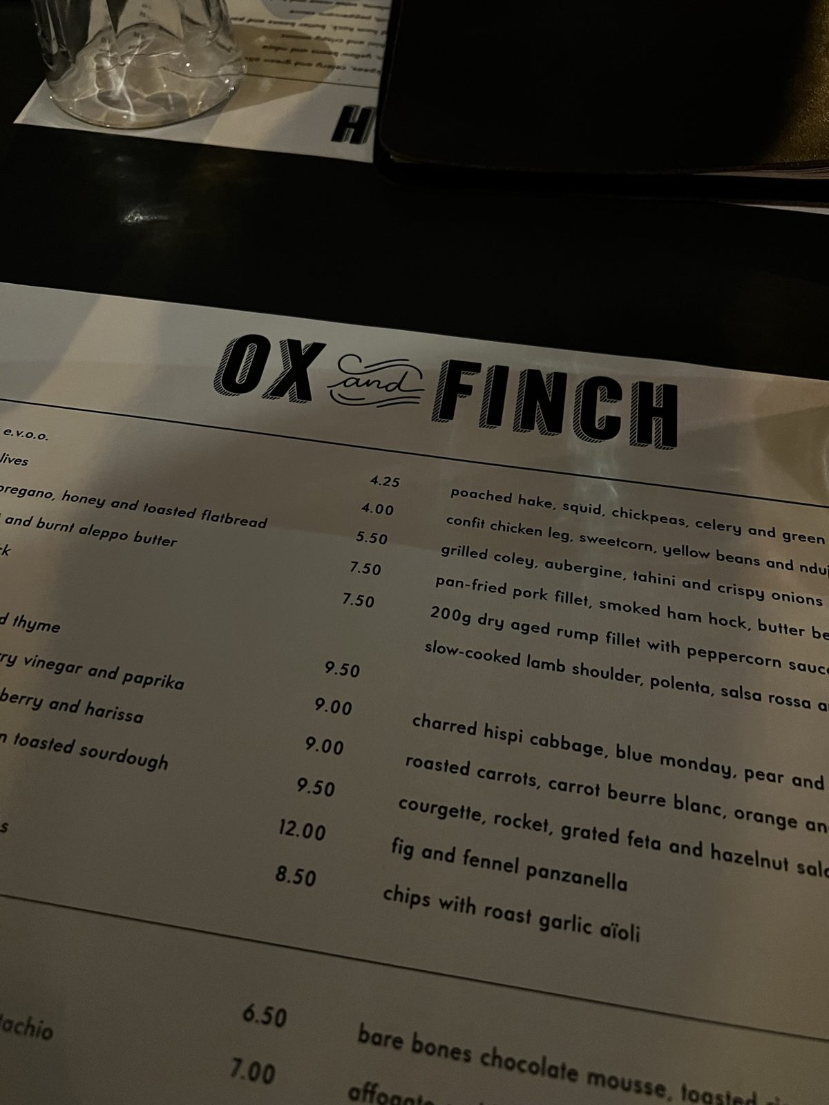 Ox and Finch menu on a dark restaurant table in Glasgow