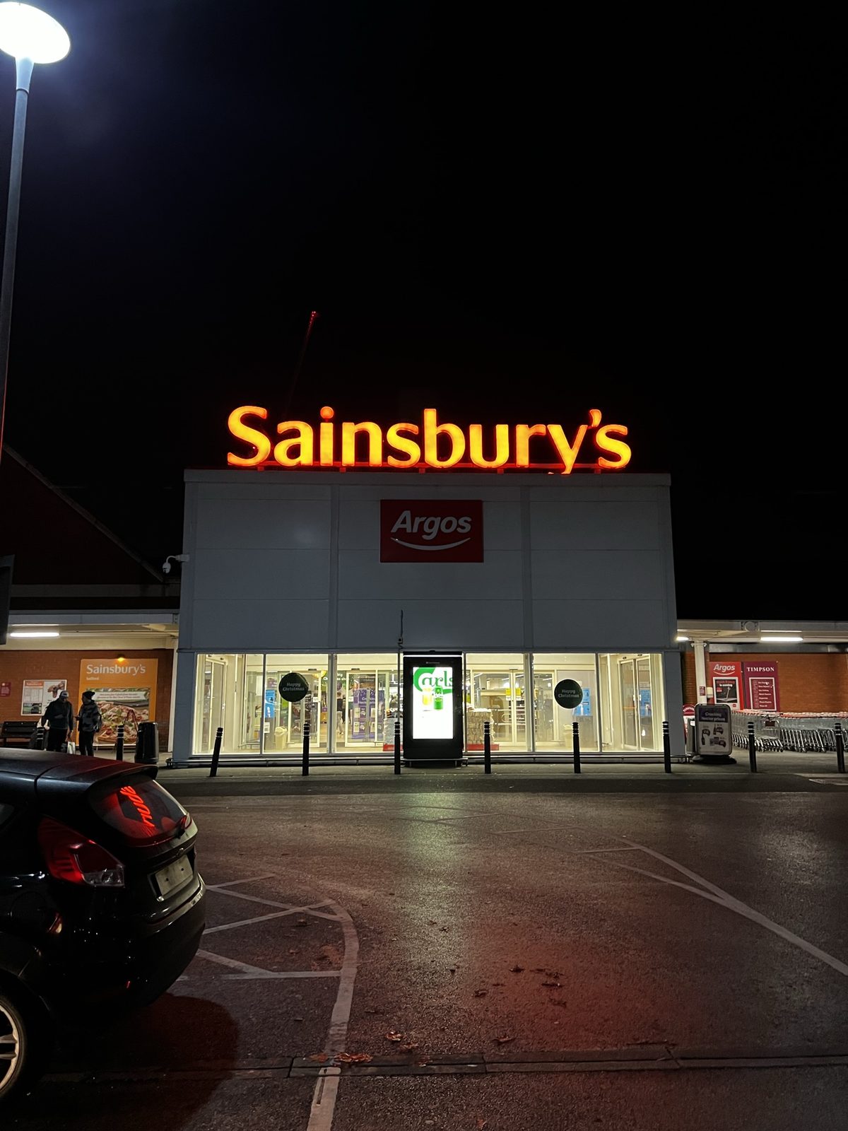 Sainsbury's storefront at night during the England road chapter